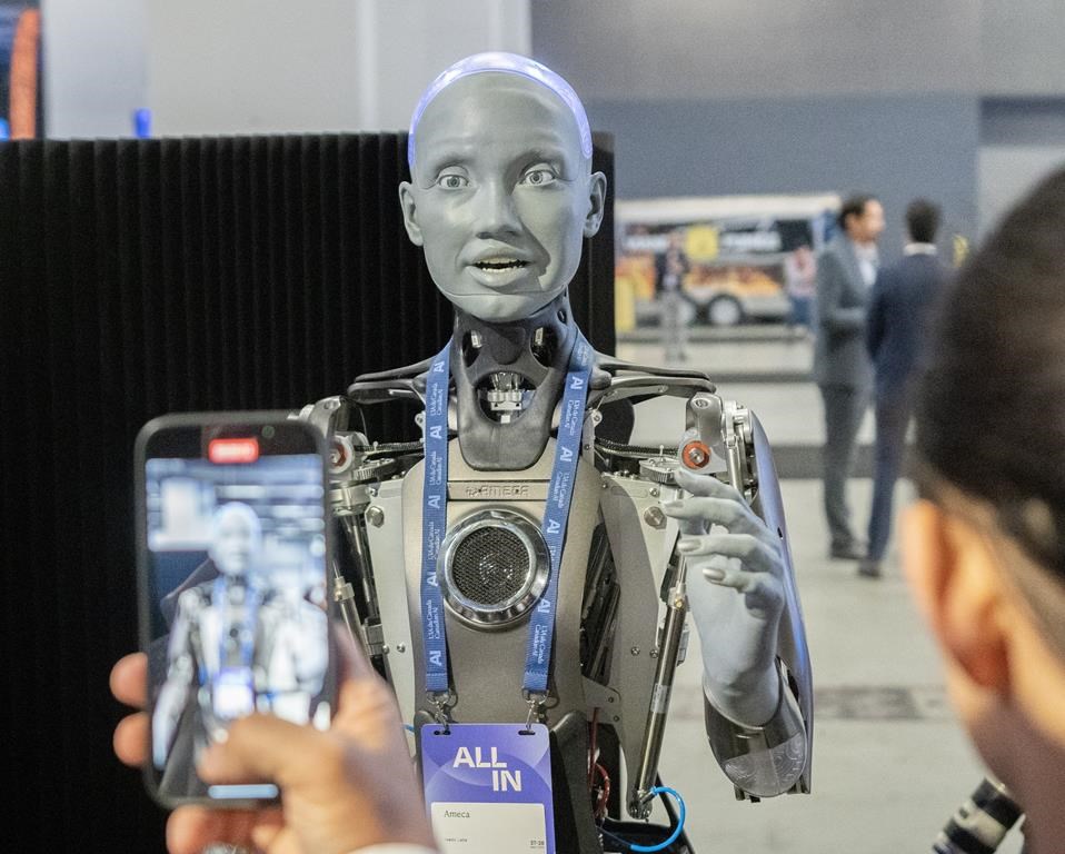 Люди фотографируют робота с искусственным интеллектом на конференции All In Artificial Intelligence, которая состоялась 27 сентября в Монреале. КАНАДСКАЯ пресса / Райан Ремиорз